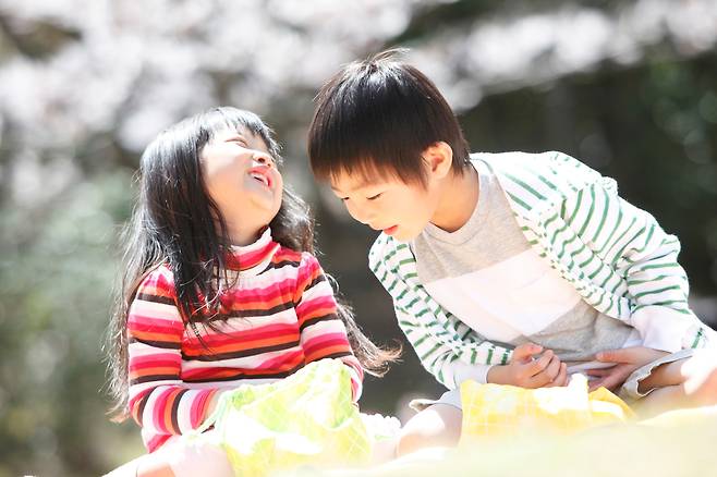 A boy looks into a girl's lunchbox. (123rf)