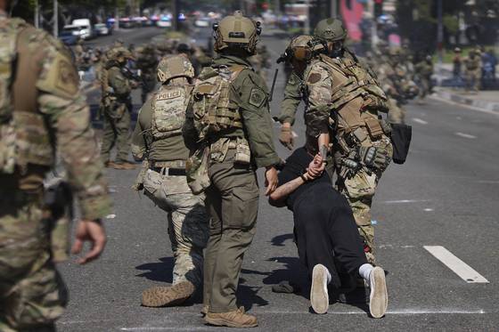 Police detain a man during a protest in the Paramount section of Los Angeles, Saturday, June 7, 2025, after federal immigration authorities conducted operations. [AP/YONHAP]