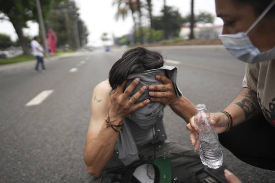A protester is given aid during a demonstration over the dozens detained in an operation by federal immigration authorities a day earlier, in Paramount, Calif., Saturday, June 7, 2025. [AP/YONHAP]