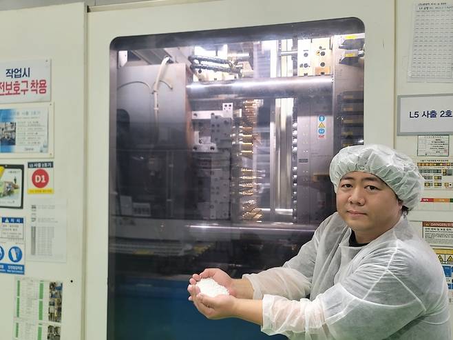 5일 제주삼다수 먹는샘물 생산라인에서 김준영 상품개발팀 대리가 재생페트칩이 사출성형기에 투입돼 프리폼이 생산되는 과정을 설명하고 있다.[사진=공동취재단]