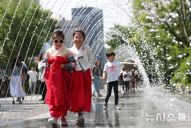 [서울=뉴시스] 홍효식 기자 = 서울 낮 최고기온이 28도까지 오른 6일 서울 종로구 광화문광장 분수대에서 어린이들이 한복을 입고 물놀이를 하고 있다. 2025.06.06. yesphoto@newsis.com