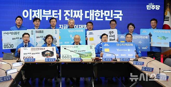 [서울=뉴시스] 권창회 기자 = 윤여준, 박찬대 더불어민주당 상임총괄선거대책위원장을 비롯한 선대위원장들이 21일 서울 여의도 더불어민주당 당사에서 열린 중앙선거대책위원회의 시작에 앞서 지역화폐 사용을 촉구하는 퍼포먼스를 하고 있다. 2025.05.21. kch0523@newsis.com