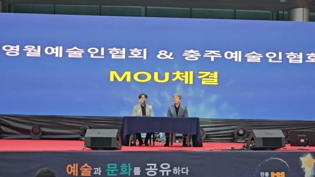 충주예술인협회 조대현 (왼쪽) 회장이 영월예술인협회 강명호 회장과 지난 7일 제1회 영월민족예술제에서 문화예술 교류 협약을 체결하고 있는 모습이다.사진=김의상 기자