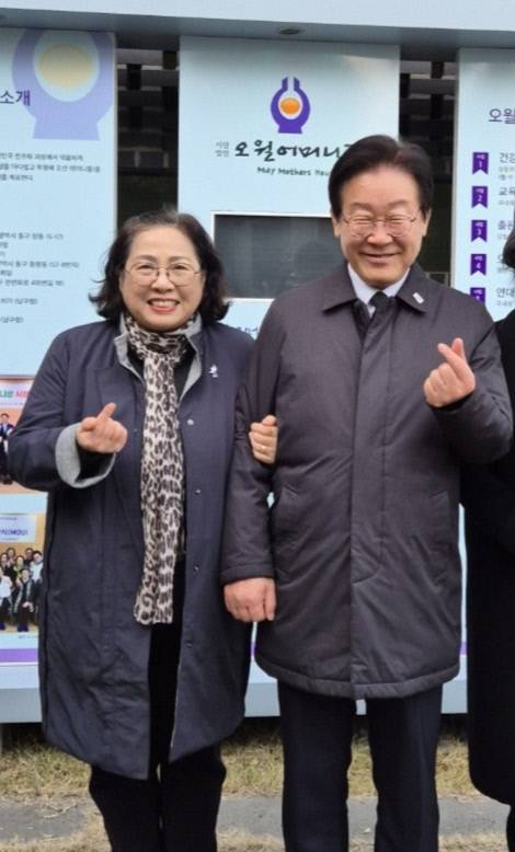 오월어머니집 회원들과 이재명 대통령이 지난해 12월 30일 간담회를 갖고 광주광역시 남구 양림동에 위치한 오월어머니집 앞에서 포즈를 취하고 있다. 오월어머니집 제공