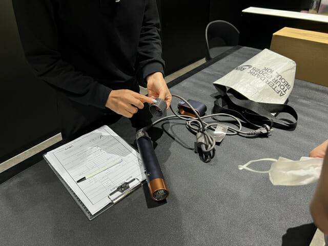 기자가 다이슨 신사 프리미엄 서비스센터에서 에어랩 멀티 스타일러 앤 드라이어 제품 점검을 받고 설명을 듣고 있다. (사진=지디넷코리아)
