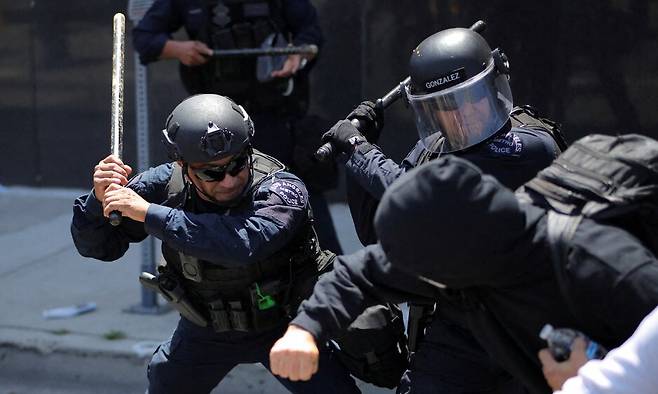 8일(현지시각) 미국 캘리포니아주 로스앤젤레스 도심에서 열린 연방정부의 이민 단속에 항의하는 시위 도중, 로스앤젤레스 메트로 경찰이 시위대와 충돌하고 있다. 로스앤젤레스/로이터 연합뉴스