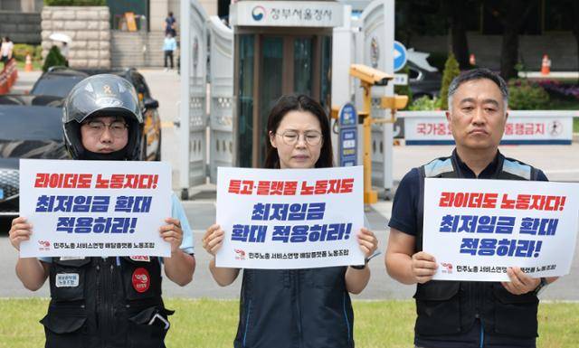 민주노총 서비스연맹 배달플랫폼노동조합 관계자들이 9일 서울 종로구 정부서울청사 앞에서 배달노동자 최저임금 적용 촉구를 위한 기자회견을 하고 있다. 뉴스1