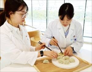 만두소 육즙을 확인하고 있는 CJ제일제당 만두 담당 연구원들. CJ제일제당 제공