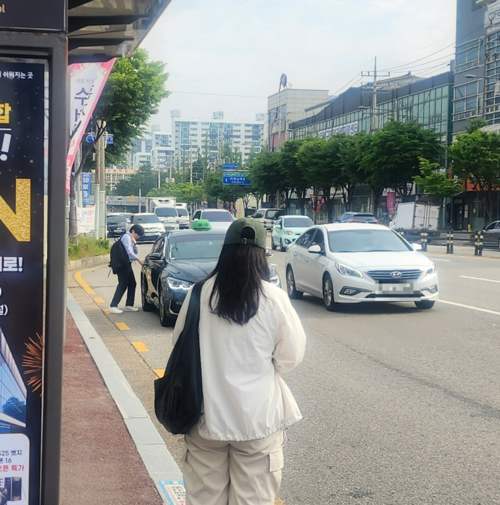 광주 시내버스 노조가 파업을 재개한 9일 오전 광주 북구 용봉동 한 버스정류장에서 한 시민이 인근에서 택시를 타는 다른 시민을 지켜보고 있다. 고귀한 기자