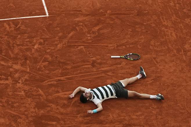 대접전 끝 ‘디펜딩 챔피언’ 카를로스 알카라스(2위·스페인)가 9일 프랑스오픈 남자 단식 결승에서 세계 1위 얀니크 신네르와 5시간29분 대접전 끝에 우승을 확정한 뒤 코트에 그대로 드러누워 있다. 파리 | AP연합뉴스