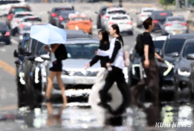 낮 최고기온이 30도를 기록한 9일 여의도공원 앞 횡단보도에 아지랑이가 피어오르고 있다.&nbsp;