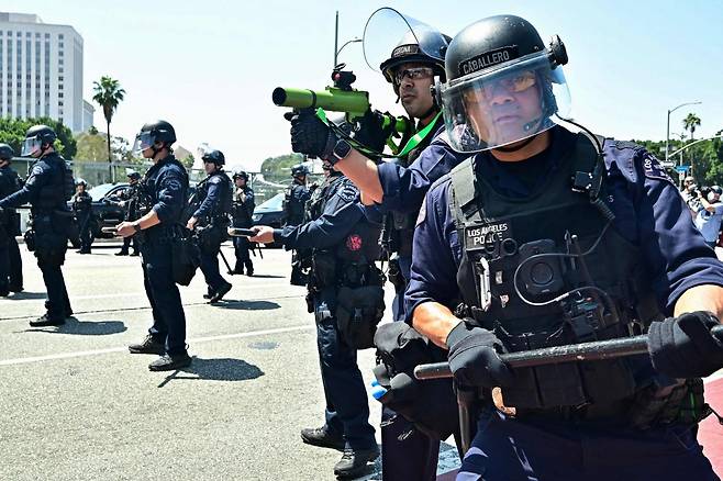 미국 캘리포니아주 로스앤젤레스 시내의 메트로폴리탄구치소 앞에서 8일(현지시간) 경찰과 시위대가 대치하고 있다. 연합뉴스
