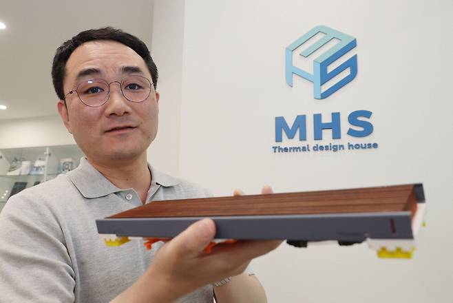 임종수 MHS 대표가 매일경제와의 인터뷰에 앞서 독자 개발한 '일체형 수랭 방식 쿨러'를 소개하고 있다.  이승환 기자