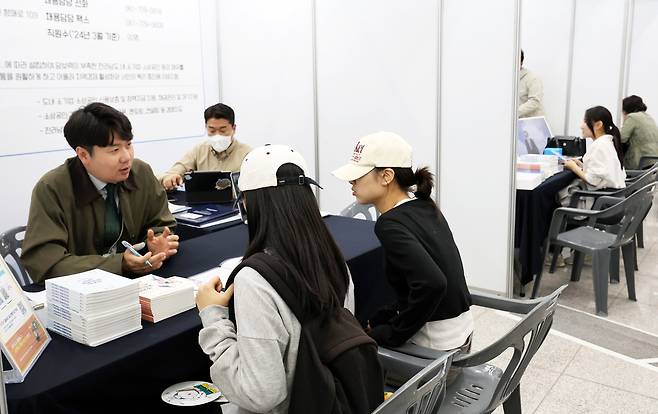 24일 광주 북구 전남대학교 컨벤션홀에서 열린 ‘2025 광주·전남 지역인재 합동 채용설명회’에서 취업준비생들이 인사담당자의 설명을 듣고 있다. [연합]