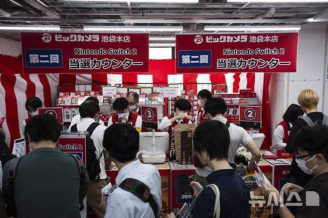 [도쿄=AP/뉴시스] 5일(현지 시간) 일본 도쿄의 한 전자제품 판매점에 닌텐도의 차세대 콘솔 ‘스위치2’를 사려는 손님들이 줄 서 있다. 이날 공식 출시된 ‘스위치2’는 전작과 많은 유사점을 지니면서도, 더 커진 화면과 향상된 그래픽을 갖춘 것이 특징이다. 2025.06.05.