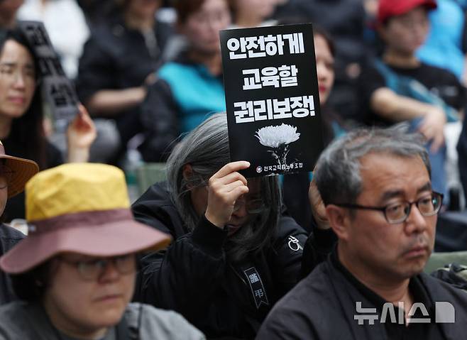 [서울=뉴시스] 김진아 기자 = 전국교직원노동조합(전교조)은 제주의 한 중학교에서 학생 측의 민원에 시달리던 고(故) 현승준 교사가 숨진 사건에 대한 엄정 수사 및 순직 인정 촉구 서명운동 결과를 9일 발표했다. 사진은 5월 24일 서울 종로구 고궁박물관 서측에서 열린 전국교직원노동조합(전교조) 창립 36주년 전국 교사결의대회에서 참가자들이 손팻말을 들고 있는 모습.이들은 안전하게 교육할 권리, 악성 민원 해결, 교육공공성 강화, 정치기본권 쟁취 등을 요구했다. 2025.05.24. bluesoda@newsis.com