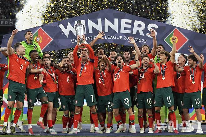 [뮌헨=AP/뉴시스] 포르투갈의 크리스티아누 호날두가 8일(현지 시간) 독일 뮌헨의 알리안츠 아레나에서 열린 2024-25 유럽축구연맹(UEFA) 네이션스리그(UNL) 스페인과의 결승전에서 승리해 우승한 후 트로피를 들고 동료들과 함께 환호하고 있다. 포르투갈은 연장까지 2-2 무승부를 기록해 승부차기 끝에 5-3으로 승리해 6년 만에 정상에 올랐다. 호날두는 후반 16분 동점 골을 넣어 A매치 138호 골을 기록했다. 2025.06.09.