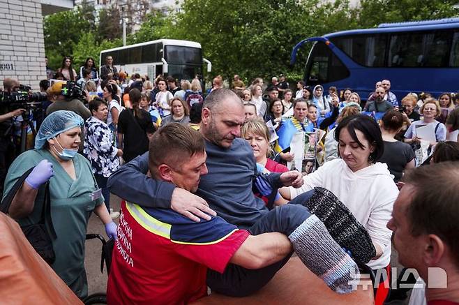 [체르느히우=AP/뉴시스] 9일(현시 시간) 타스통신에 따르면 러시아 국방부는 이날 우크라이나와의 합의에 따라 25세 미만 병사 1차 그룹을 귀환시켰고, 이에 상응하는 수의 우크라이나 전쟁포로를 송환했다고 밝혔다. 사진은 지난달 24일(현지 시간) 우크라이나 체르느히우에서 러시아와 우크라이나 간 포로 교환으로 석방된 한 부상 군인이 의료진 도움을 받으며 들것에 타고 있는 모습. 2025.06.09.