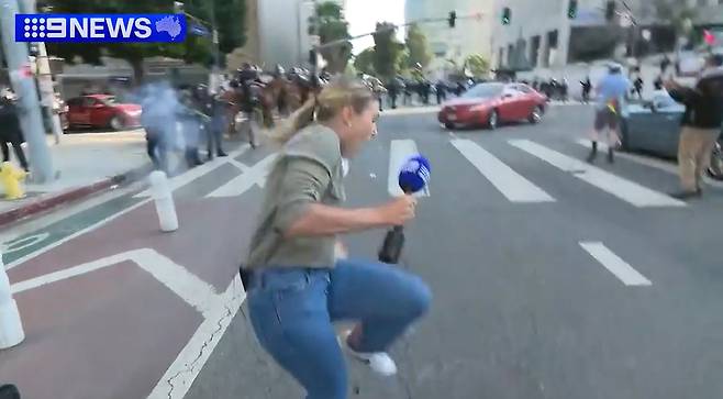 호주 9뉴스 기자 로렌 토마시가 경찰이 쏜 고무탄에 맞는 모습 [9뉴스 홈페이지 캡처]