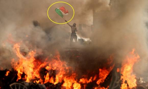 지난 8일 LA 시위에서 한 남성이 불타는 차량 위에서 멕시코 국기를 흔들고 있다. 로이터 연합뉴스