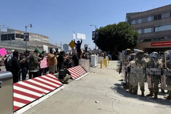 8일(현지시간) 미국 로스앤젤레스(LA) 도심의 연방 구금시설인 ‘메트로폴리탄 디텐션 센터’(Metropolitan Detention Center) 앞에서 주방위군이 시위대와 대치하고 있다. 시위대는 미 이민세관단속국(ICE)의 대대적인 불법 이민자 단속에 반발하는 시위를 사흘째 벌이고 있다. 2025.6.9 연합뉴스