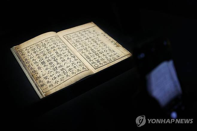 조선의 빛 '훈민정음' (서울=연합뉴스) 강민지 기자 = 9일 서울 용산구 국립중앙박물관에서 열린 용산 개관 20주년 기념 특별전 '새 나라 새 미술: 조선 전기 미술 대전'에서 관계자가 '훈민정음'을 살펴보고 있다. 전시는 15~16세기 도자, 서화, 불교미술 등을 선보인다. 2025.6.9 mjkang@yna.co.kr