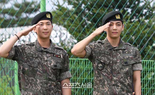 방탄소년단(BTS)의 RM(왼쪽, 김남준)과 뷔(김태형)가 10일 강원도 춘천시 신북읍 체육공원에서 진행된 전역 행사에서 팬과 취재진을 향해 거수 경례를 하고 있다. RM은 육군 제15보병사단 군악대에서, 뷔는 2군단 군사경찰 특수임무대에서 1년 6개월 동안 군복무를 했다. 2025. 6. 10.  춘천 | 박진업 기자 upandup@sportsseoul.com
