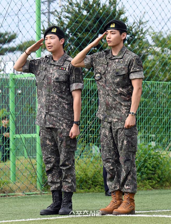 방탄소년단(BTS)의 RM(왼쪽, 김남준)과 뷔(김태형)가 10일 강원도 춘천시 신북읍 체육공원에서 진행된 전역 행사에서 팬과 취재진을 향해 거수 경례를 하고 있다. RM은 육군 제15보병사단 군악대에서, 뷔는 2군단 군사경찰 특수임무대에서 1년 6개월 동안 군복무를 했다. 2025. 6. 10.  춘천 | 박진업 기자 upandup@sportsseoul.com