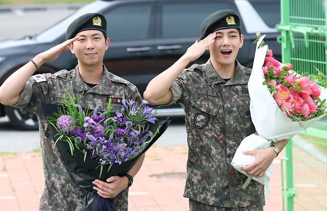 방탄소년단(BTS)의 RM(김남준, 30)과 뷔(김태형, 29)가 10일 오전 강원도 춘천시 신북읍 체육공원 축구장에서 군 복무를 마친 뒤 전역 인사를 하고 있다. /뉴스1