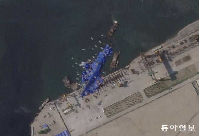 지난달 21일 북한 함경북도 청진시 청진조선소에서 진수식 도중 쓰러진 구축함 위성사진. 북한은 이례적으로 이튿날 사고 소식을 보도했다. 위성 감시를 피할 수 없다고 판단했기 때문으로 보인다. 동아일보DB
