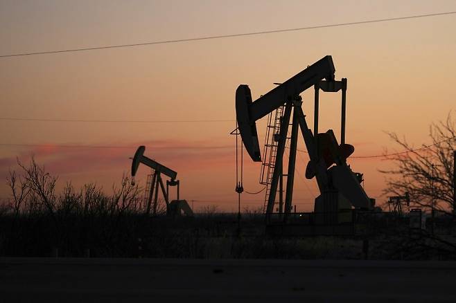 국제 유가가 올해 배럴당 50달러 밑으로 떨어질 수도 있다고 S&P글로벌 상품인사이츠가 9일(현지시간) 전망했다. 지난 2월 24일 미국 뉴멕시코주의 홉스에서 펌프잭들이 일출 속에 석유를 끌어올리고 있다. AP 연합