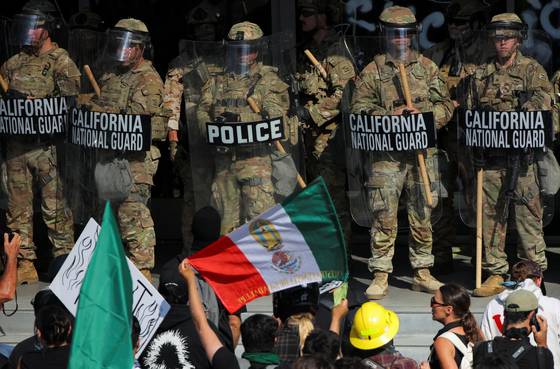 9일 미국 캘리포니아주 로스앤젤레스에서 이민 단속 반대 시위가 계속되는 가운데 시위대가 캘리포니아주 방위군과 대치하고 있다. 로이터=연합뉴스