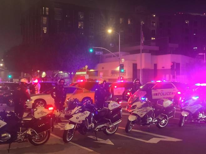 미국 캘리포니아주 로스앤젤레스 다운타운에서 9일(현지시간) 경찰관들이 시위대에 맞서 도로를 통제하고 있다.