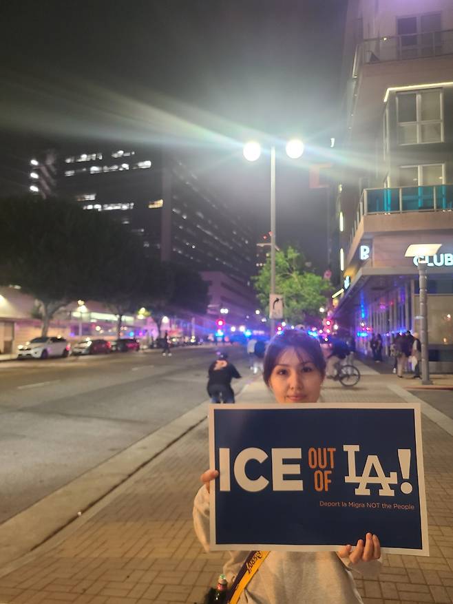 미국 캘리포니아주 로스앤젤레스에서 9일(현지시간) 열린 시위에 참여한 폴라가 '이민세관단속국은 LA에서 나가라'라고 적힌 팻말을 들고 서 있다.