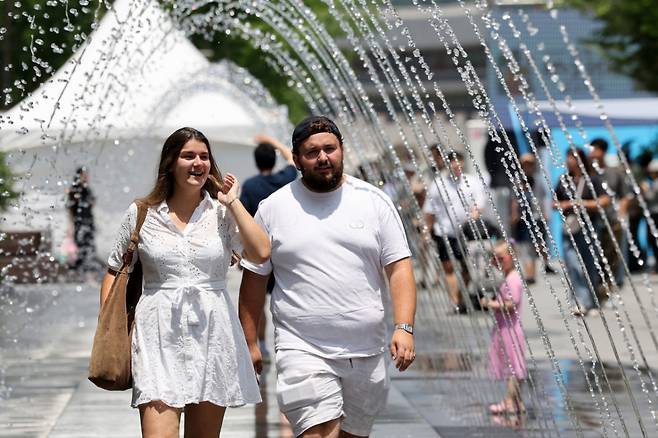 (서울=뉴스1) 이동해 기자 = 30도 안팎의 낮더위가 이어지고 있는 8일 서울 광화문광장 분수터널에서 외국인 관광객들이 더위를 식히고 있다. 2025.6.8/뉴스1 Copyright (C) 뉴스1. All rights reserved. 무단 전재 및 재배포, AI학습 이용 금지. /사진=(서울=뉴스1) 이동해 기자