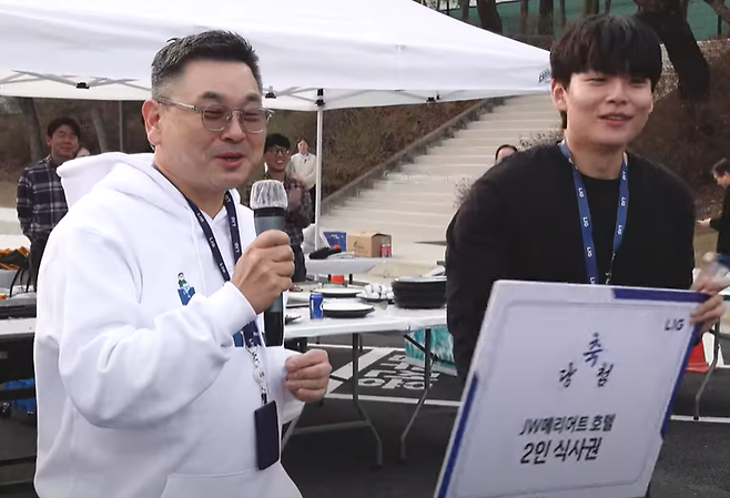 구본상(왼쪽) LIG그룹 회장이 LIG넥스원에서 진행한 ‘2025 신입사원 웰컴행사’에서 신입사원에 경품을 전달하고 있다. [LIG넥스원 유튜브 캡쳐]