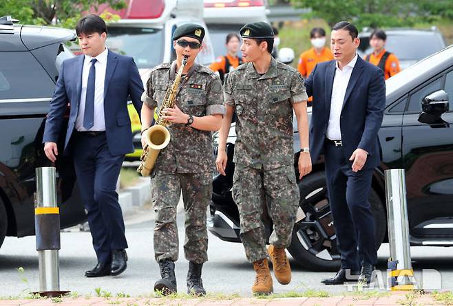 [춘천=뉴시스] 김혜진 기자 = 군 복무를 마친 방탄소년단 RM, 뷔가 10일 오전 강원 춘천시 한 부대 인근에서 전역인사를 하고 있다. 2025.06.10. jini@newsis.com