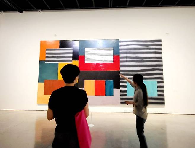 [사진=박현주미술전문기자] 대구미술관 이정희 전시팀장이 션 스컬리의 수평 수직 작품을 설명하고 있다. 2025.06.09. hyun@newsis.com *재판매 및 DB 금지