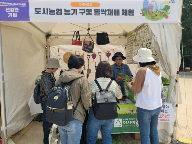 아시아종묘의 '도시농업백화점 채가원’ 부스에서 시민에게 보리싹 키우기 키트를 나눠주고 있다. 아시아종묘