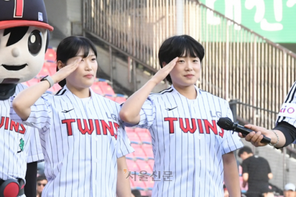 김해나(오른쪽) 소위와 조시은 소위가 10일 서울 잠실구장에서 열린 LG 트윈스와 SSG 랜더스의 경기에 앞서 경례하고 있다. 김 소위는 천안함 피격 당시 전사한 김태석 원사의 딸, 조 소위는 제2연평해전 당시 전사한 조천형 상사의 딸이다. 2025.6.10 해군 제공