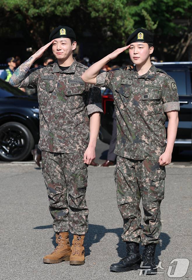 방탄소년단(BTS)의 정국과 지민(오른쪽)이 11일 오전 경기도 연천군 연천공설운동장에서 군복무를 마친 뒤 전역 인사를 전하고 있다. ⓒ News1 권현진 기자