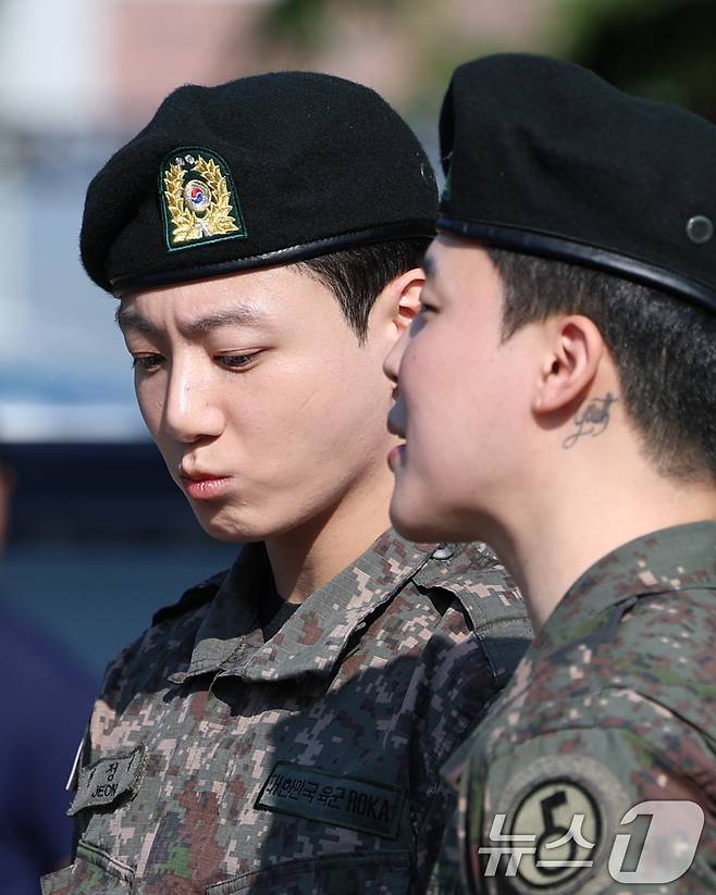 방탄소년단(BTS)의 정국과 지민(오른쪽)이 11일 오전 경기도 연천군 연천공설운동장에서 군복무를 마친 뒤 전역 인사를 전하고 있다. ⓒ News1 권현진 기자