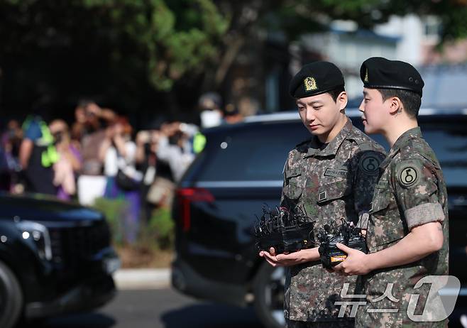 방탄소년단(BTS)의 정국과 지민(오른쪽)이 11일 오전 경기도 연천군 연천공설운동장에서 군복무를 마친 뒤 전역 인사를 전하고 있다. ⓒ News1 권현진 기자