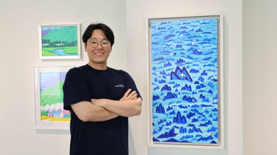 핀휠 유명곤 대표, 허남성 작가의 '춤추는 산과물' 앞에서 사진 촬영