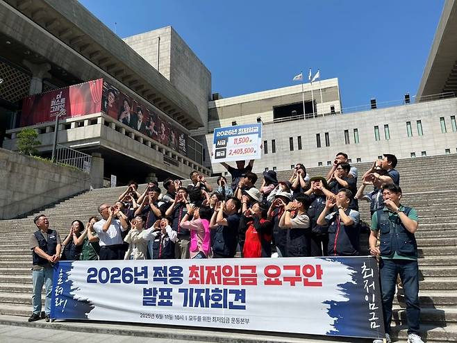 11일 오전 서울 종로구 세종문화회관 앞에서 열린 '2026년 적용 최저임금 요구안 발표' 기자회견에서 노동계와 시민단체가 구호를 외치고 있다. 사진=김형구 기자
