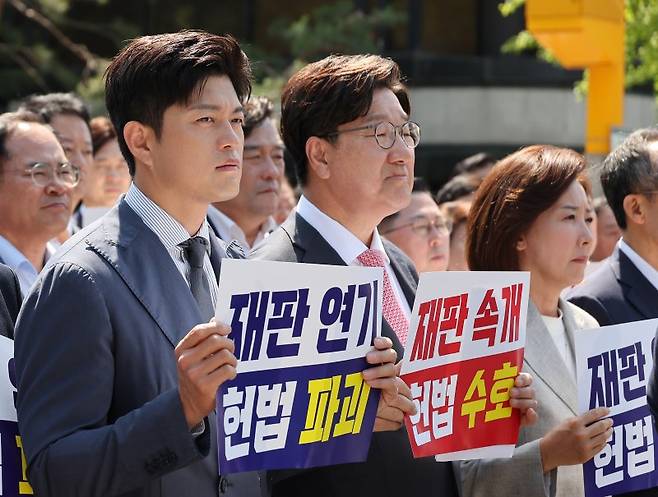 국민의힘 김용태 비상대책위원장과 권성동 원내대표가 11일 이재명 대통령의 공직선거법 위반 사건의 파기환송심을 사실상 무기한 연기한 서울고등법원 앞에서 열린 현장 의원총회에 참석해 있다. 연합뉴스