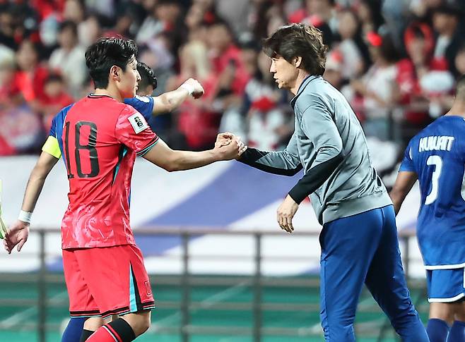 축구대표팀 이강인(왼쪽)과 홍명보 감독이 손을 맞잡고 있다. [뉴스1]
