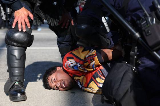 현지시간 10일 캘리포니아 로스앤젤레스에서 LA경찰이 시위자를 체포하고 있다. LA엔 이날 오후 8시를 기해 야간통행금지령이 발령됐다. EPA=연합뉴스