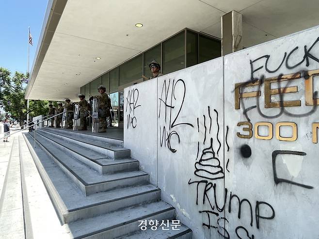 도널드 트럼프 미국 대통령의 이민 단속에 항의하는 시위가 5일째 진행 중인 10일(현지시간) 캘리포니아주 로스앤젤레스 도심의 연방기관 청사 외벽에 낙서가 적혀있다. 로스앤젤레스 | 김유진 특파원