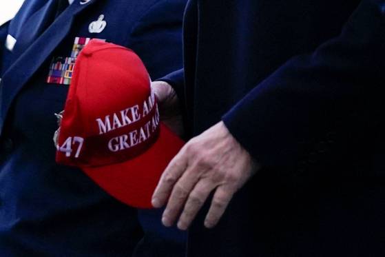 U.S. President Donald Trump holds a cap with his campaign slogan, "Make America Great Again," as he arrives at Philadelphia International Airport in Philadelphia on March 22. [REUTERS/YONHAP]